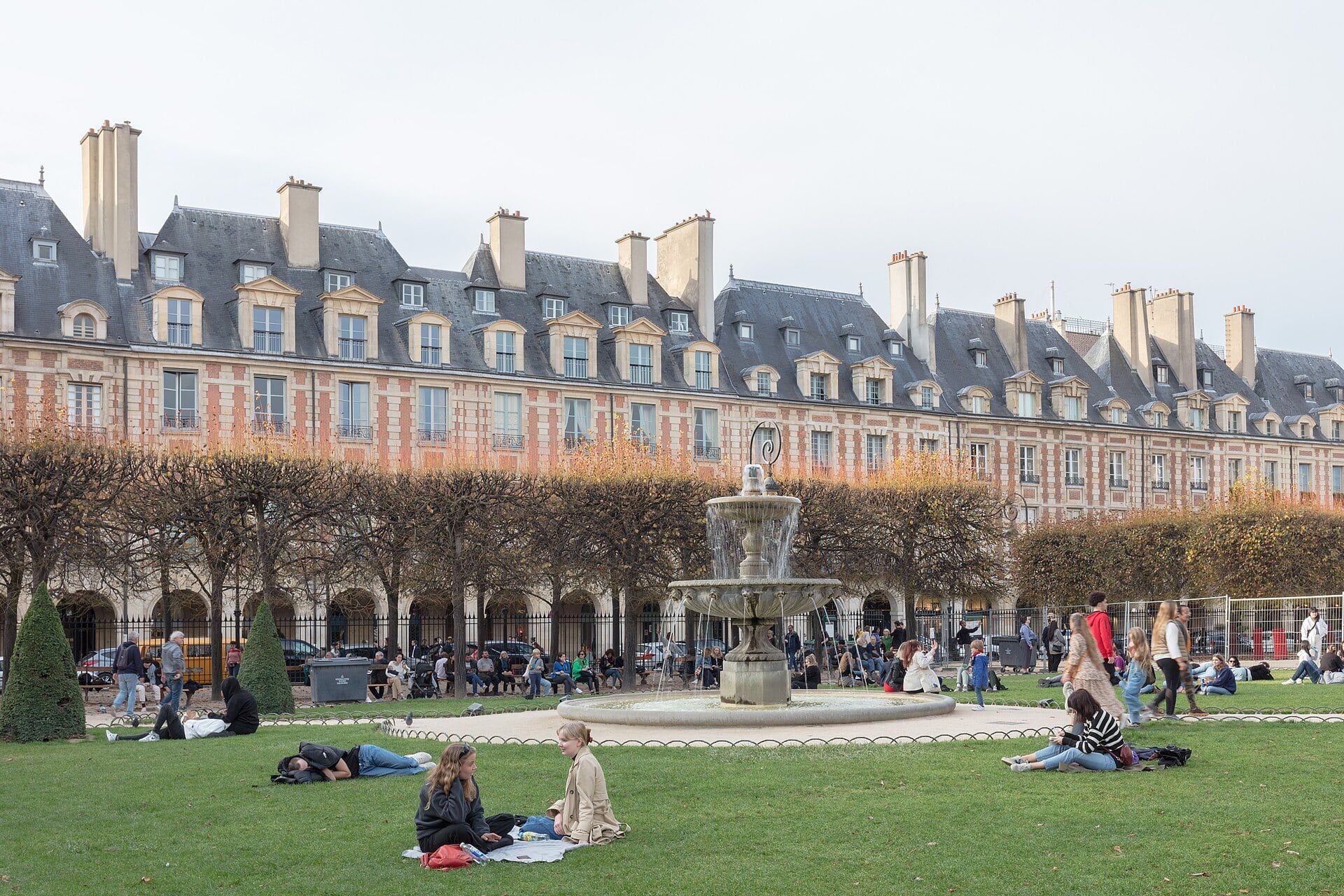 La place des Vosges, ses pavillons de brique rouge et sa fontaine, à la limite du 3e et du 4e arrondissement