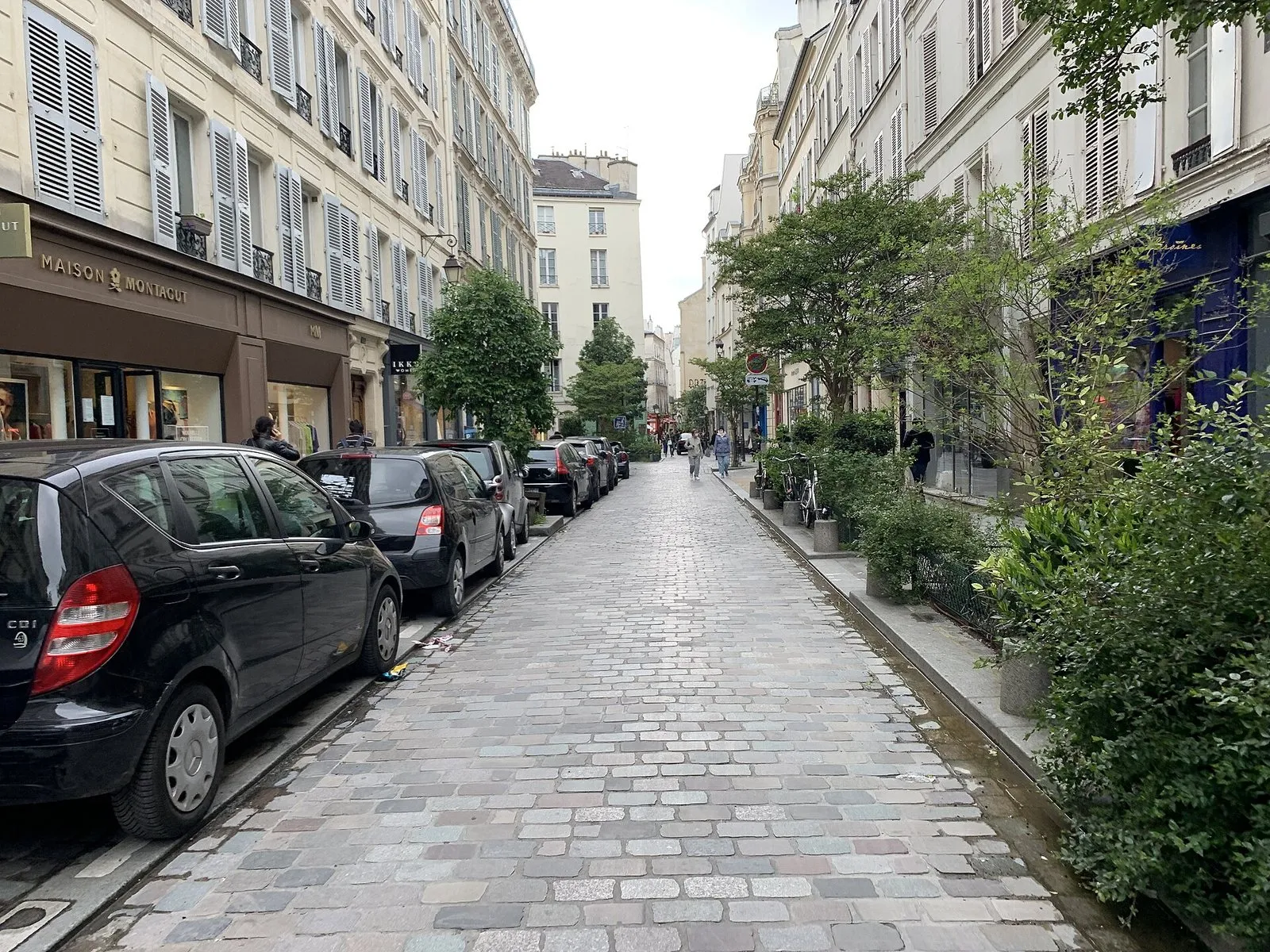 La rue des Rosiers pavée, bordée de devantures